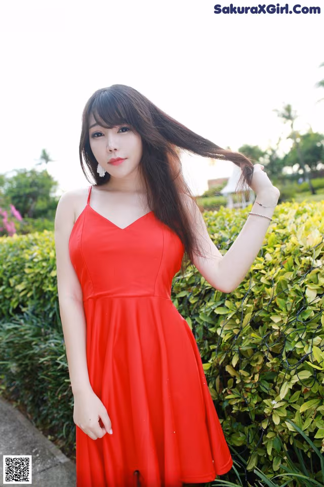 A woman in a red dress posing for a picture.