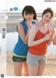 Two young women standing next to each other on a beach.