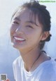 A young woman with a white shirt smiles at the camera.