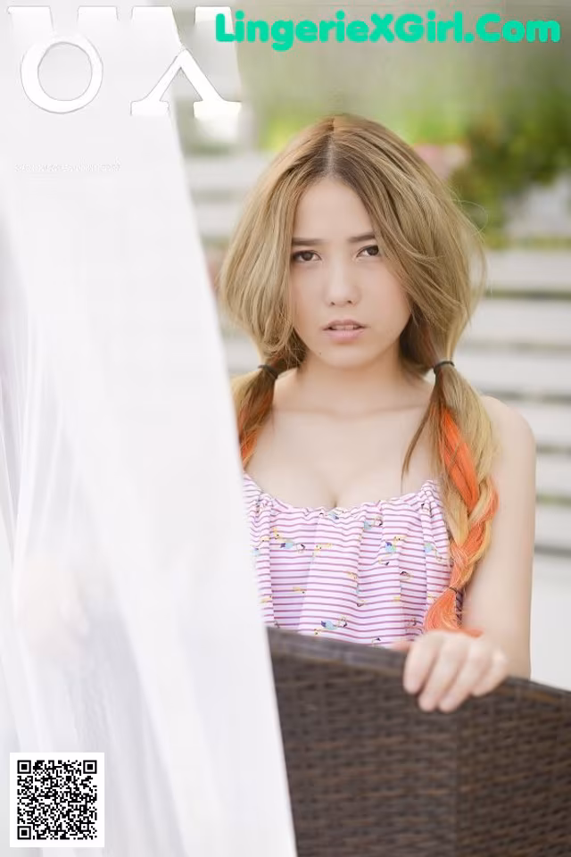 A young woman with long blonde hair is posing for a magazine cover.