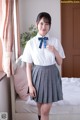 A woman in a school uniform posing for a picture.