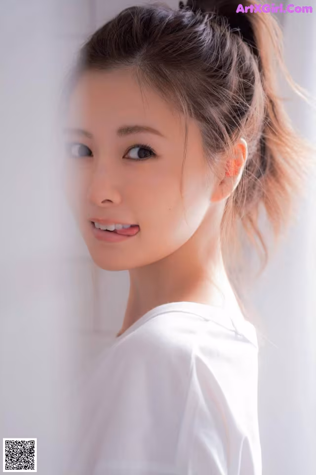 A woman with a ponytail in a white shirt.