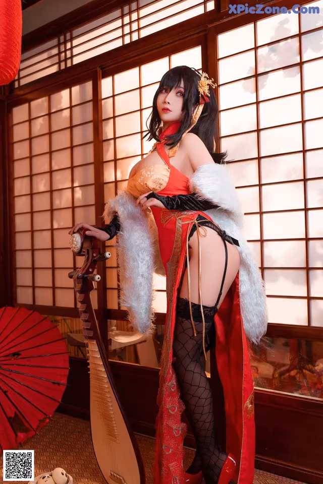 A woman in a red and black outfit holding a red umbrella.