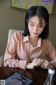 A woman sitting at a table looking at a tablet computer.