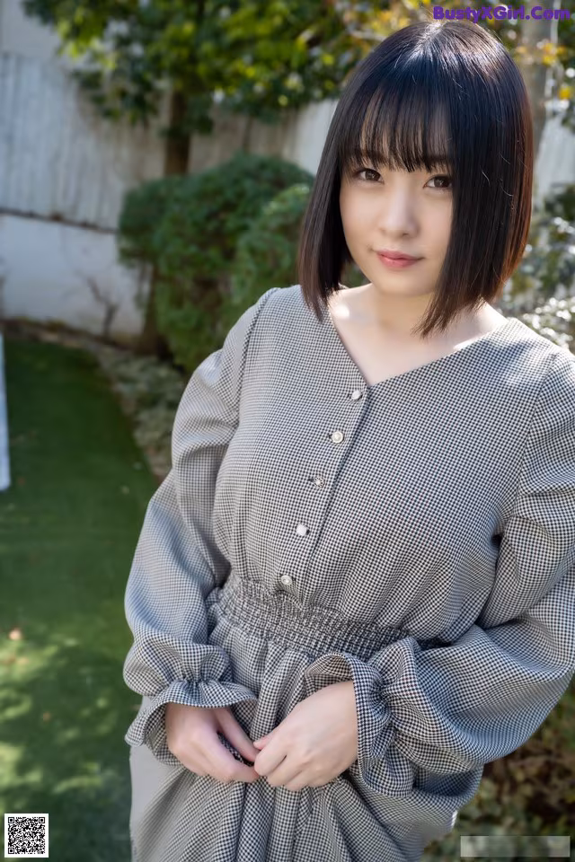 A woman in a black and white checkered dress posing for a picture.