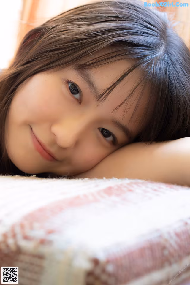 A young girl laying on top of a bed.