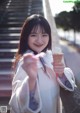 A woman holding an ice cream cone in her hand.